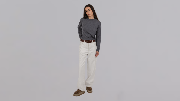Woman wearing carpenter jeans with a relaxed knit top in a modern Australian fashion boutique.