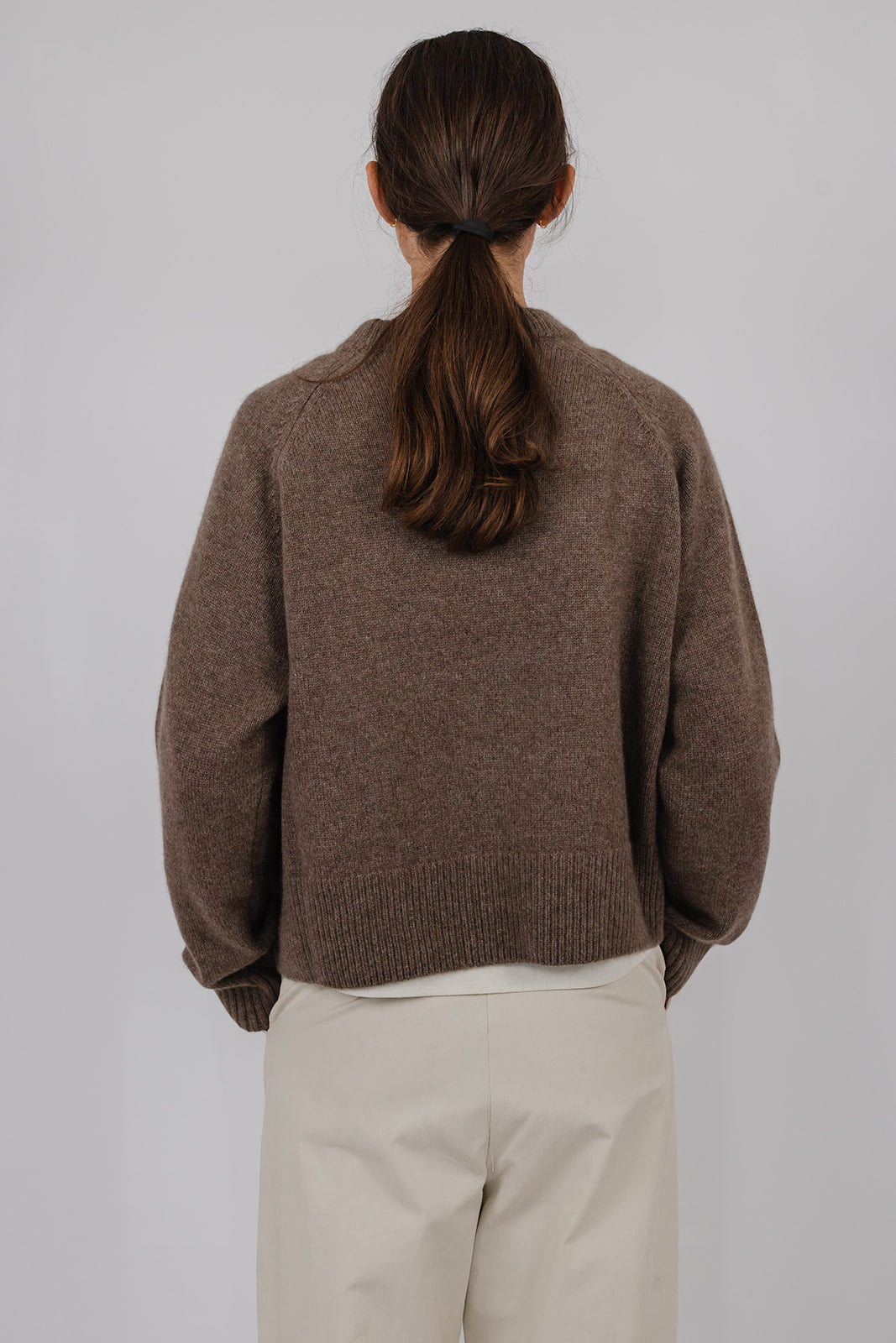 Model wearing a taupe cashmere knit with oat coloured pants by Vic and Bert.