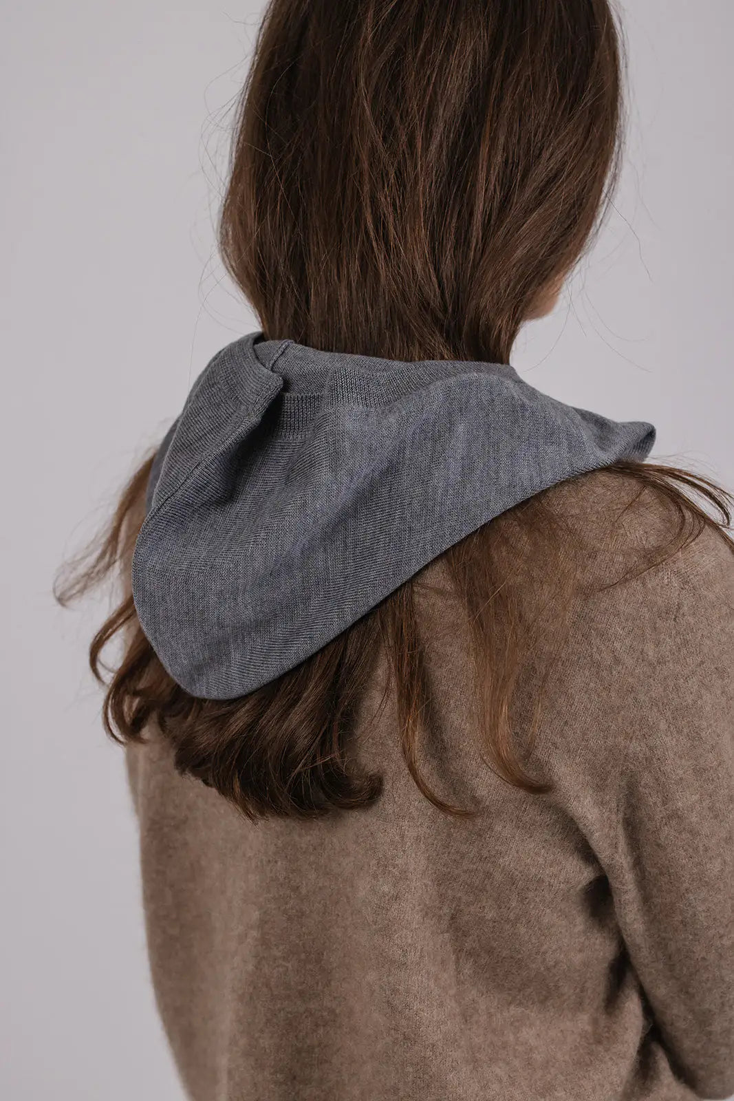 Model wearing a grey merino wool hood by Vic and Bert.