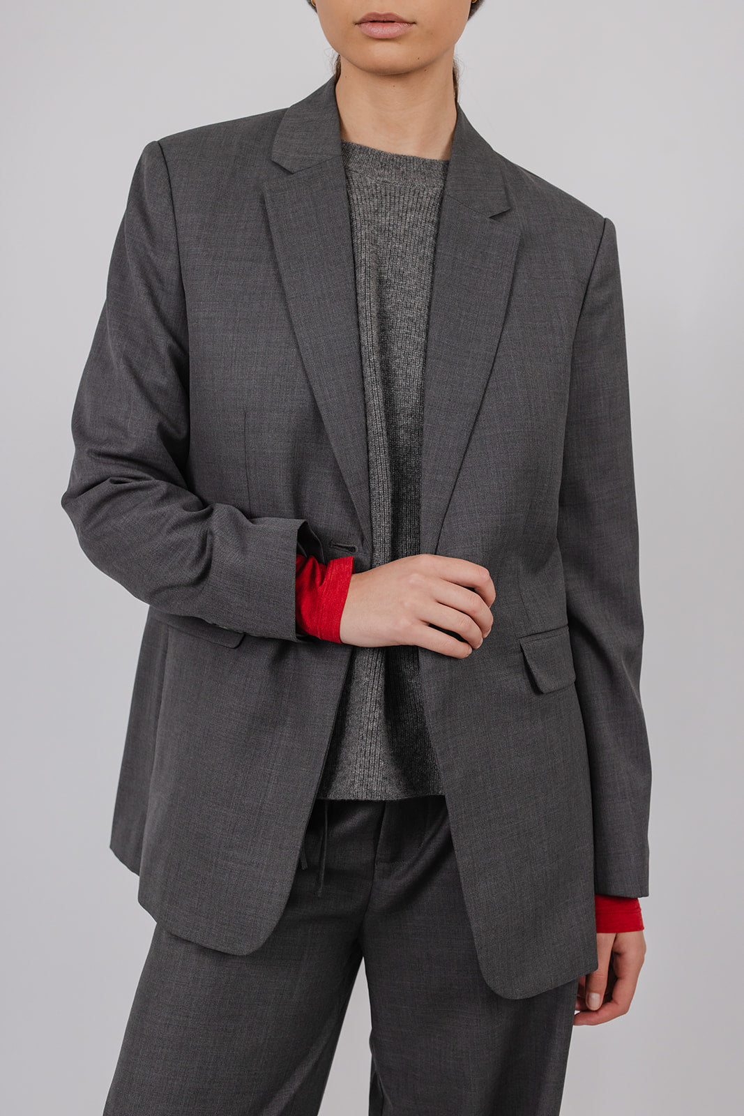 Model wearing a grey tailored suit by Vic and Bert.