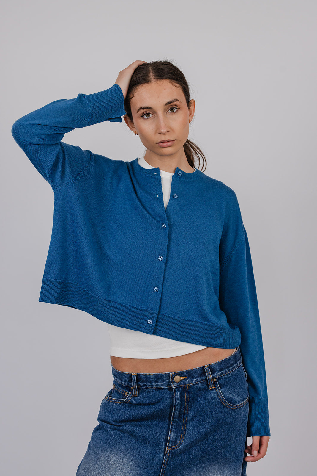 Model wearing a blue merino cardigan and blue carpenter jeans by Vic and Bert.