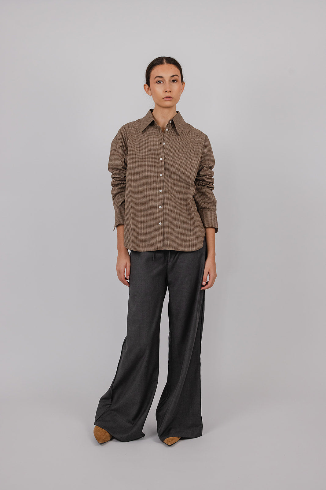 Model wearing a brown check brushed cotton collared shirt and grey suit pants by Vic and Bert.