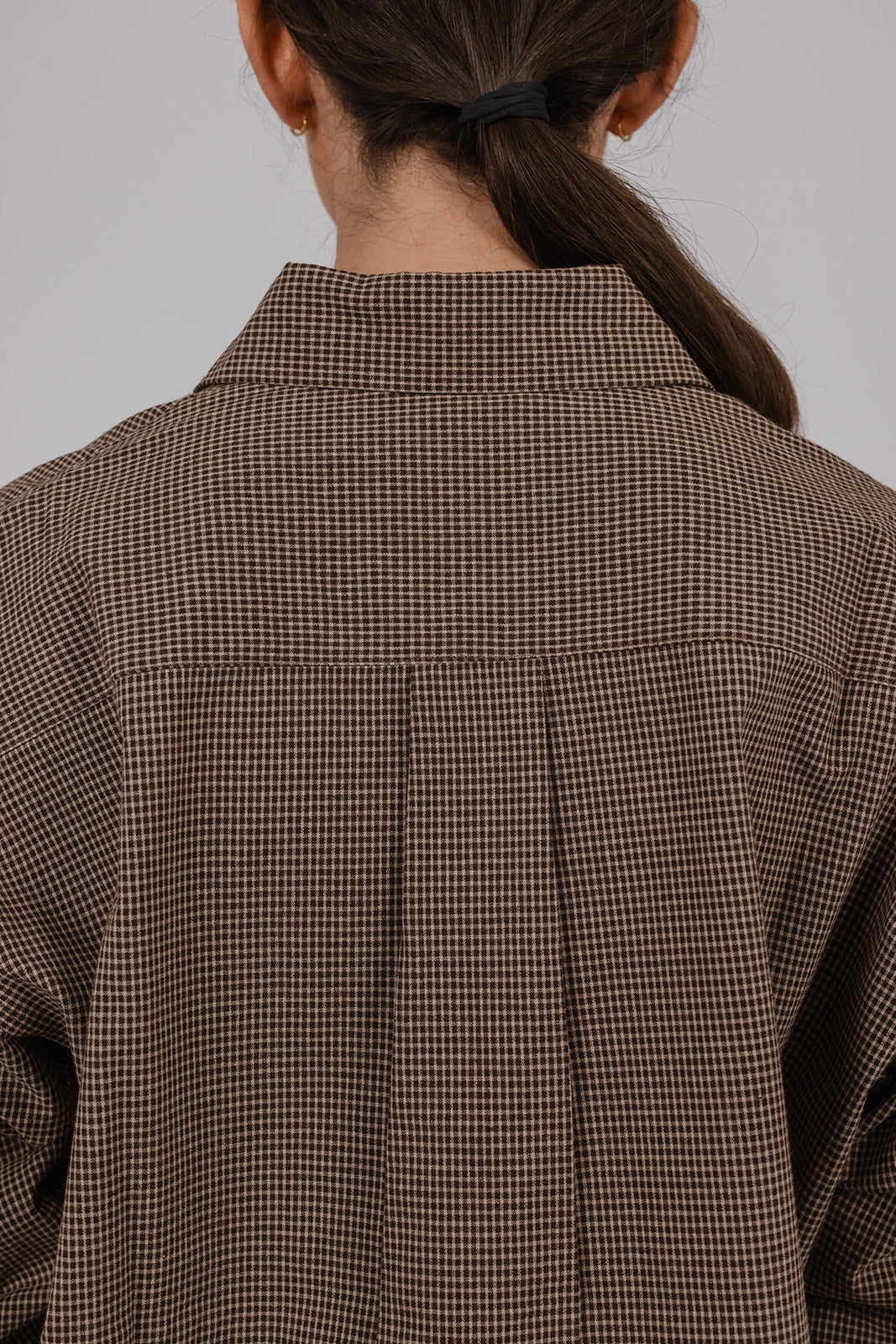 Model wearing a brown check brushed cotton collared shirt and grey suit pants by Vic and Bert.