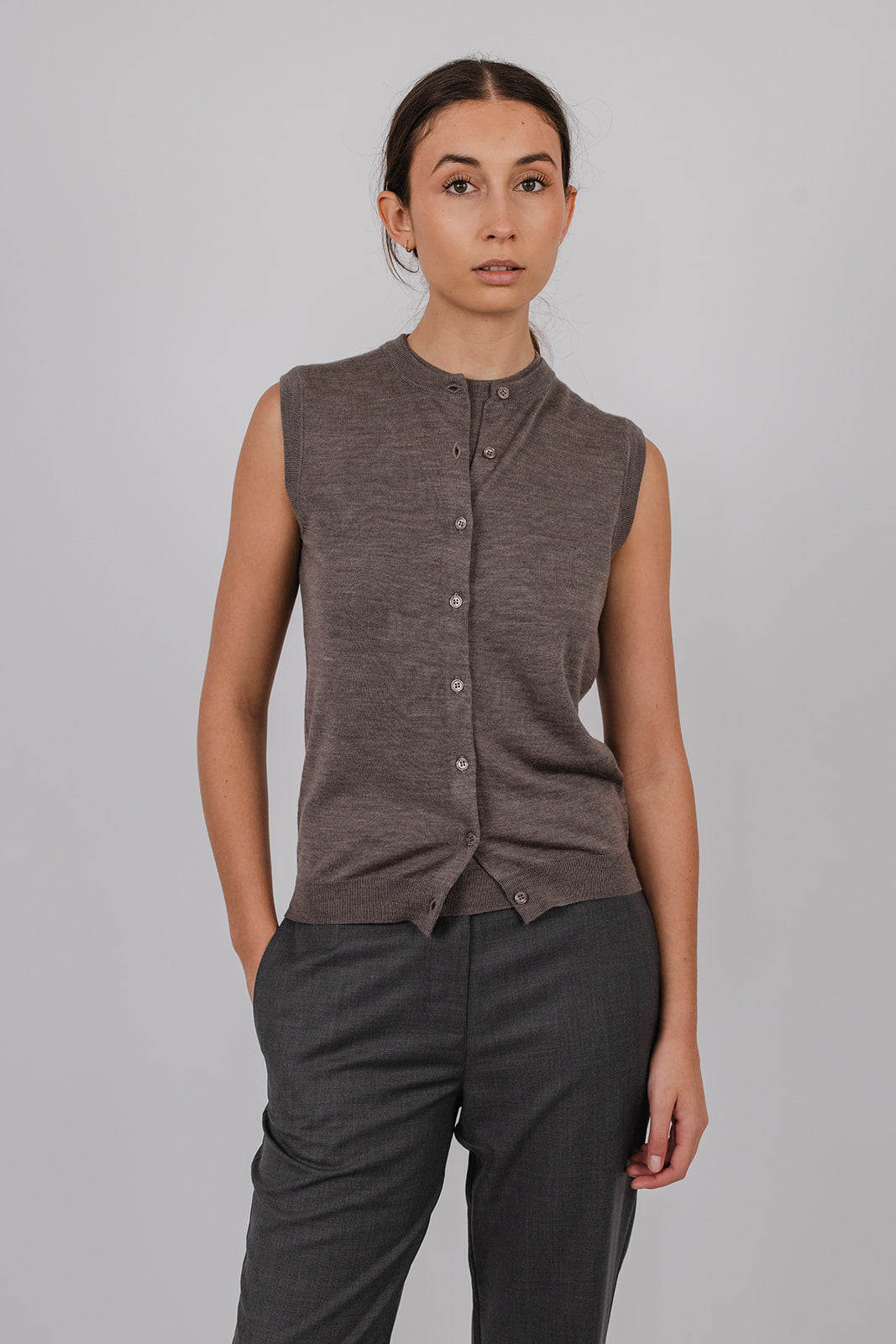 Model wearing a sleeveless merino vest and grey tailored suit pants by Vic and Bert.