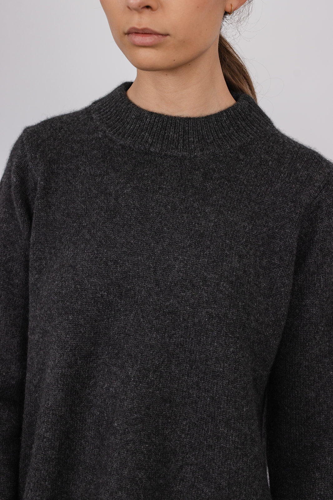 Model wearing a charcoal cashmere a-line knit by Vic and Bert.