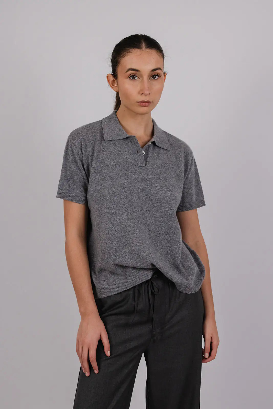 Model wearing a grey cashmere polo by Vic and Bert.