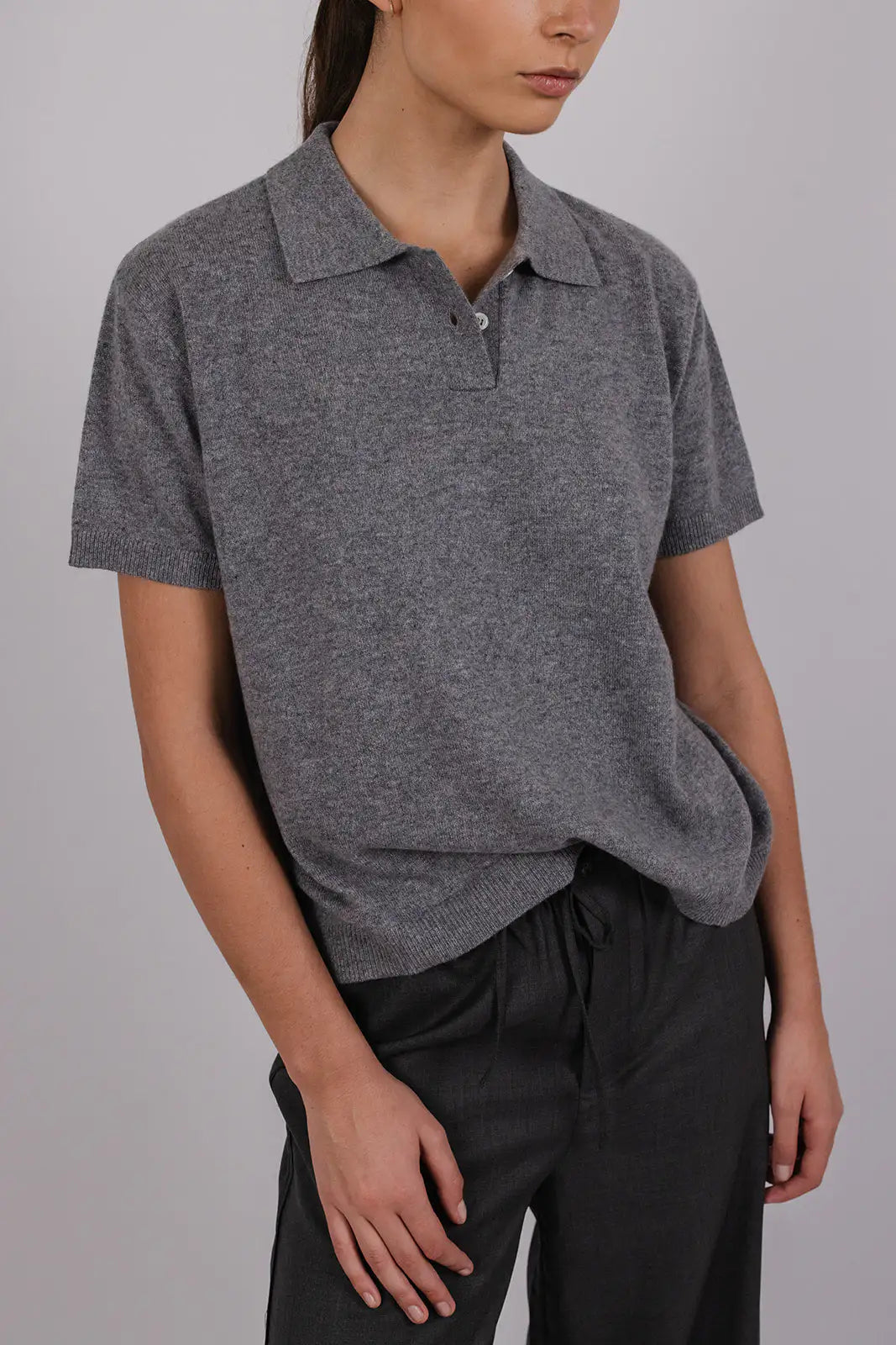 Model wearing a grey cashmere polo by Vic and Bert.