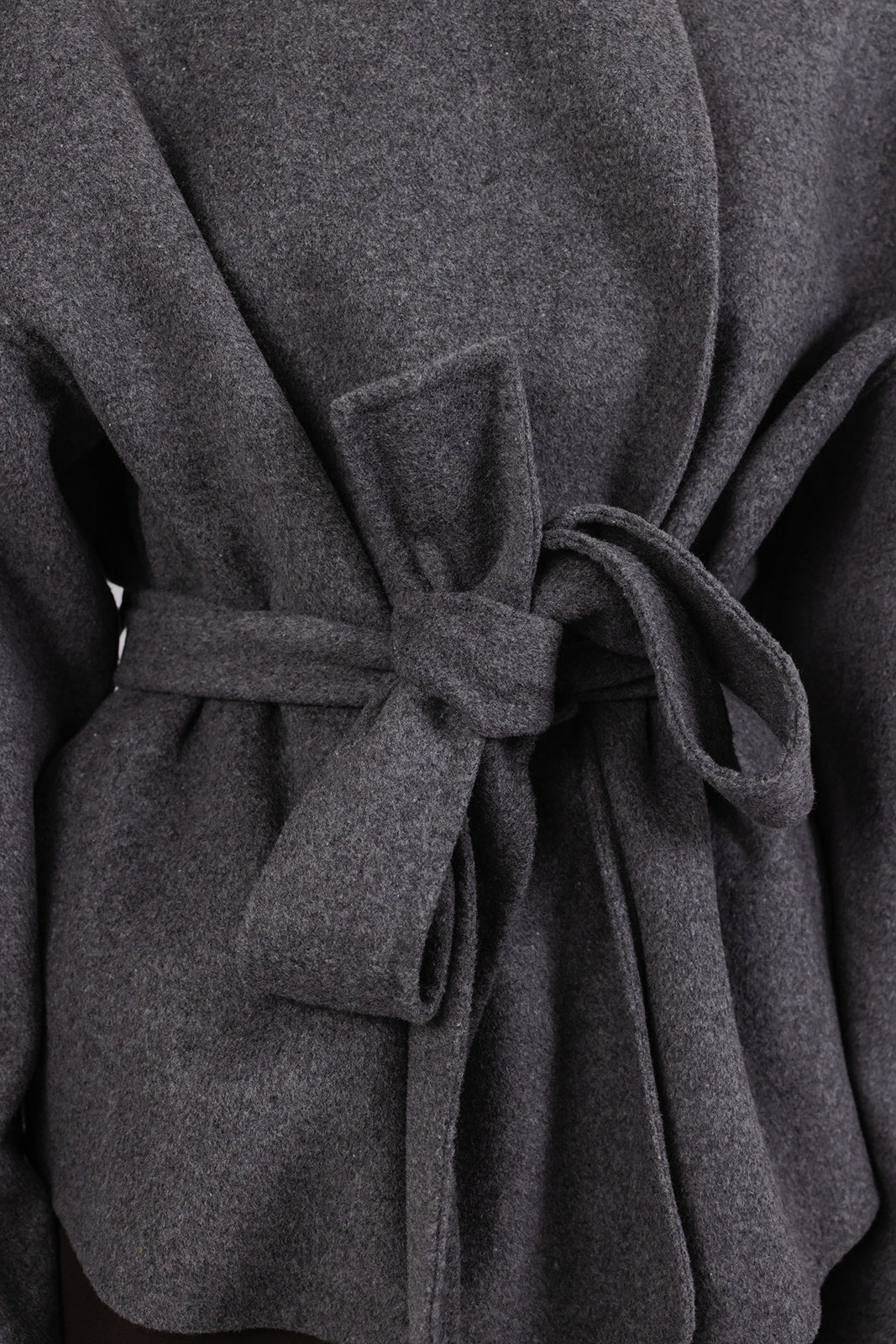 Close-up of a the Bella Jacket - a grey coat with a tie waist
